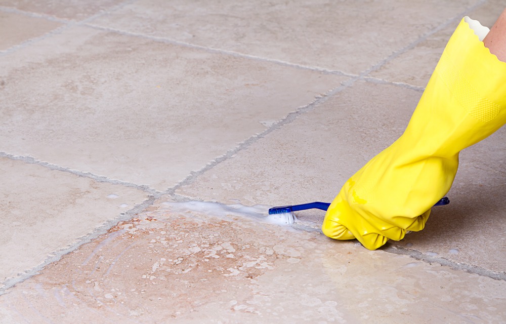 scrubbing grout with toothbrush